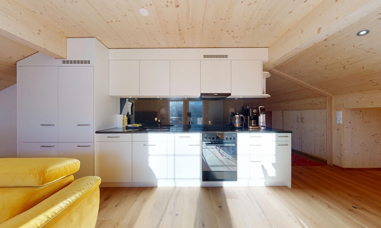 cuisine avec plans de travail, armoires blanches, plafond en bois, wood ceiling, et armoires à panneau plat