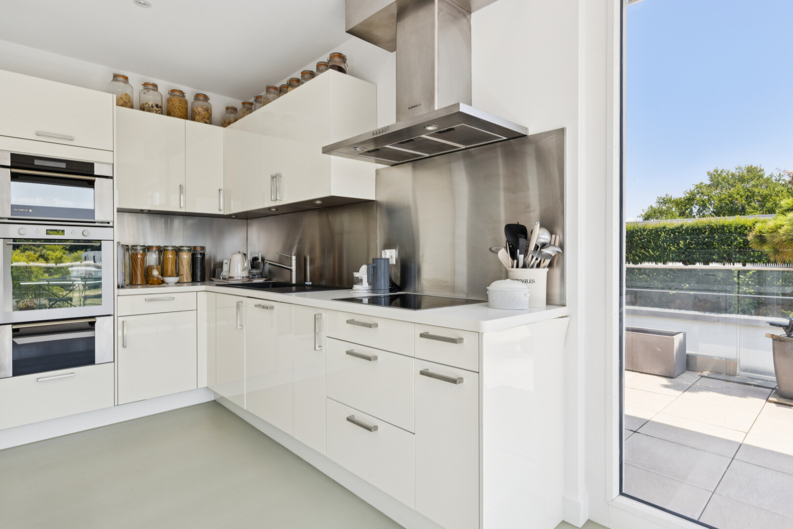 küche mit dunstabzugshaube, light countertops, arbeitsplatten, white cabinets, und weiße schränke