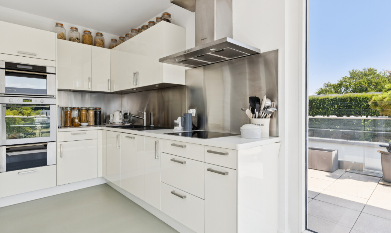 küche mit dunstabzugshaube, light countertops, arbeitsplatten, white cabinets, und weiße schränke
