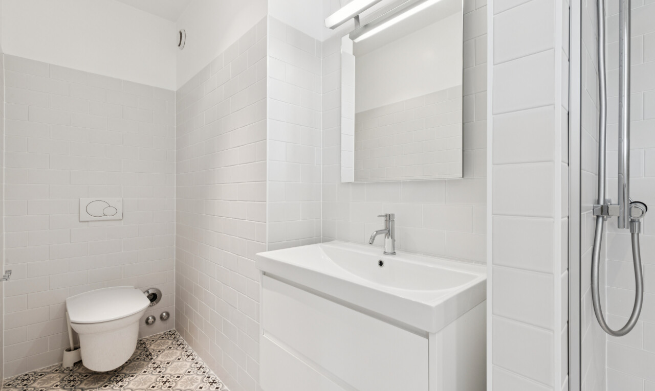 salle de bains avec lavabo (ou coiffeuse selon le contexte), miroir, inside property, salle de bain complète, et light floor