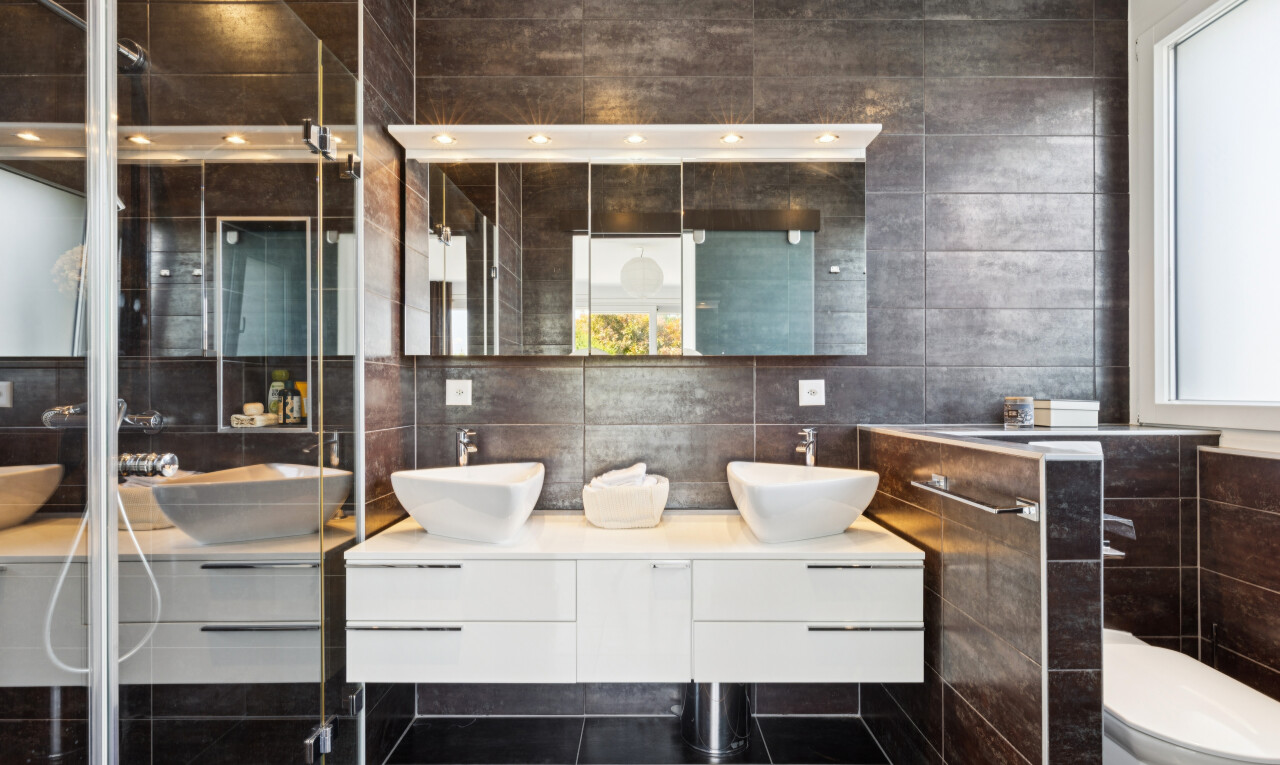 salle de bains avec tile wall, mur en carrelage, double vasque, salle de bain complète, et dark floor