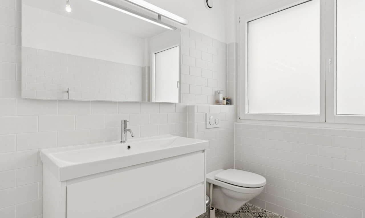 salle de bains avec tile wall, mur en carrelage, lavabo (ou coiffeuse selon le contexte), inside property, et light floor