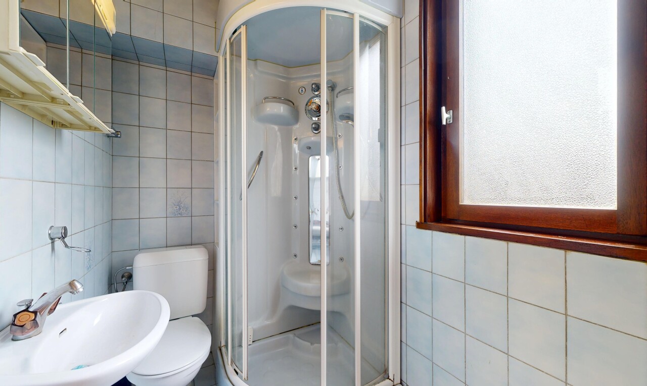 salle de bains avec tile wall, mur en carrelage, inside property, douche, et évier