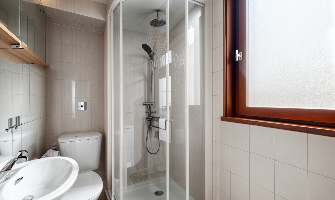 salle de bains avec tile wall, mur en carrelage, inside property, douche, et évier