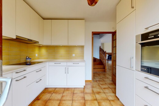 cuisine avec armoires blanches, four, plans de travail, backsplash, et dosseret