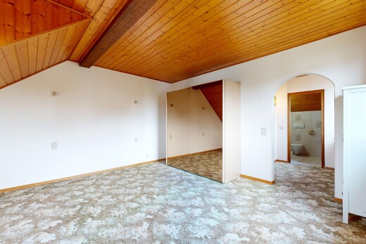 pièce vide avec passages en arc, drywall, cloison sèche, inside property, et beamed ceiling