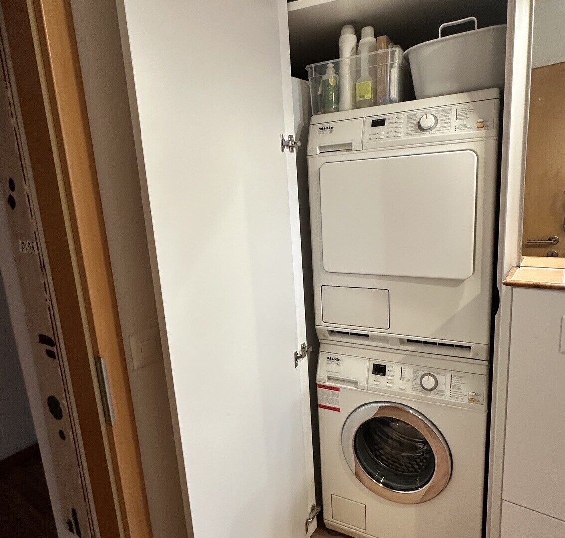 buanderie avec lave-linge et sèche-linge superposés, buanderie, et inside property