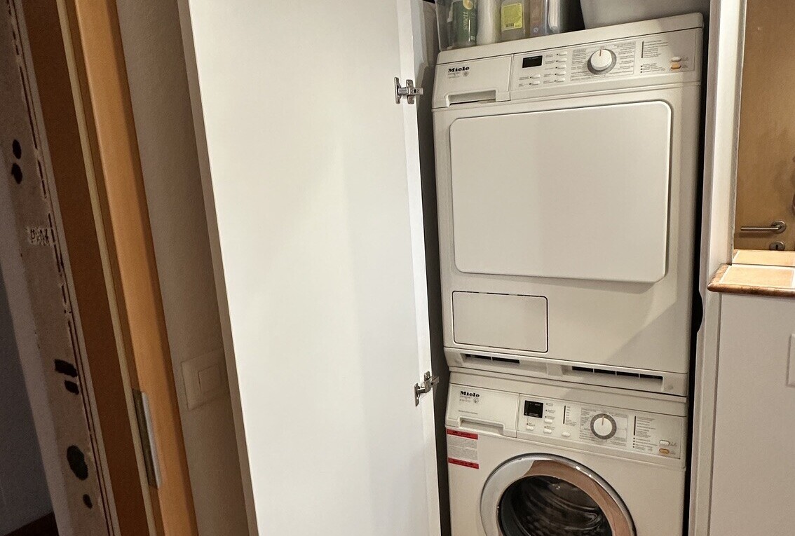 buanderie avec lave-linge et sèche-linge superposés, buanderie, et inside property