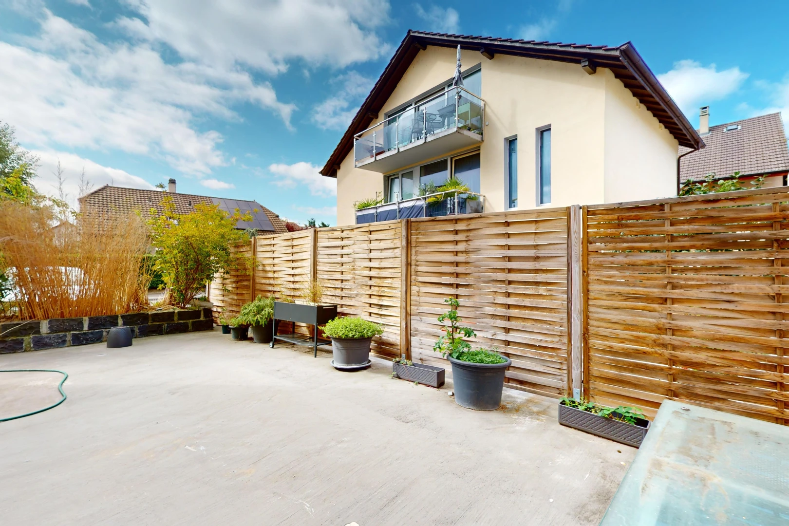 façade avec balcon, clôture, et patio