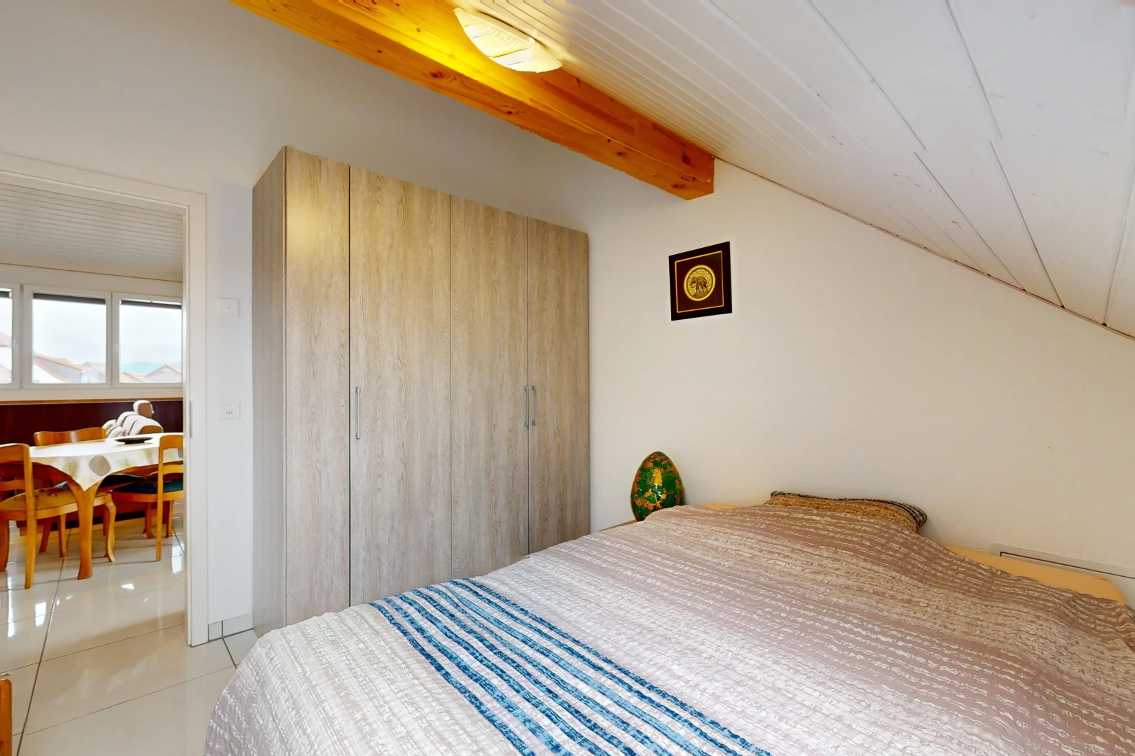 chambre avec lumière naturelle, carrelage, et poutres apparentes