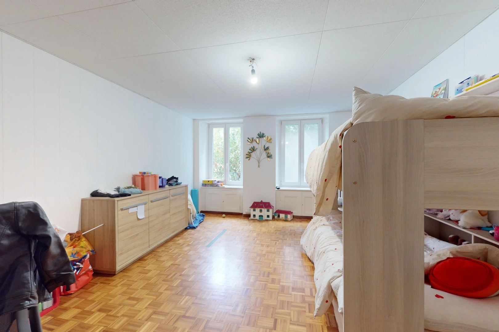 chambre avec porte-fenêtre, parquet, et lumière naturelle