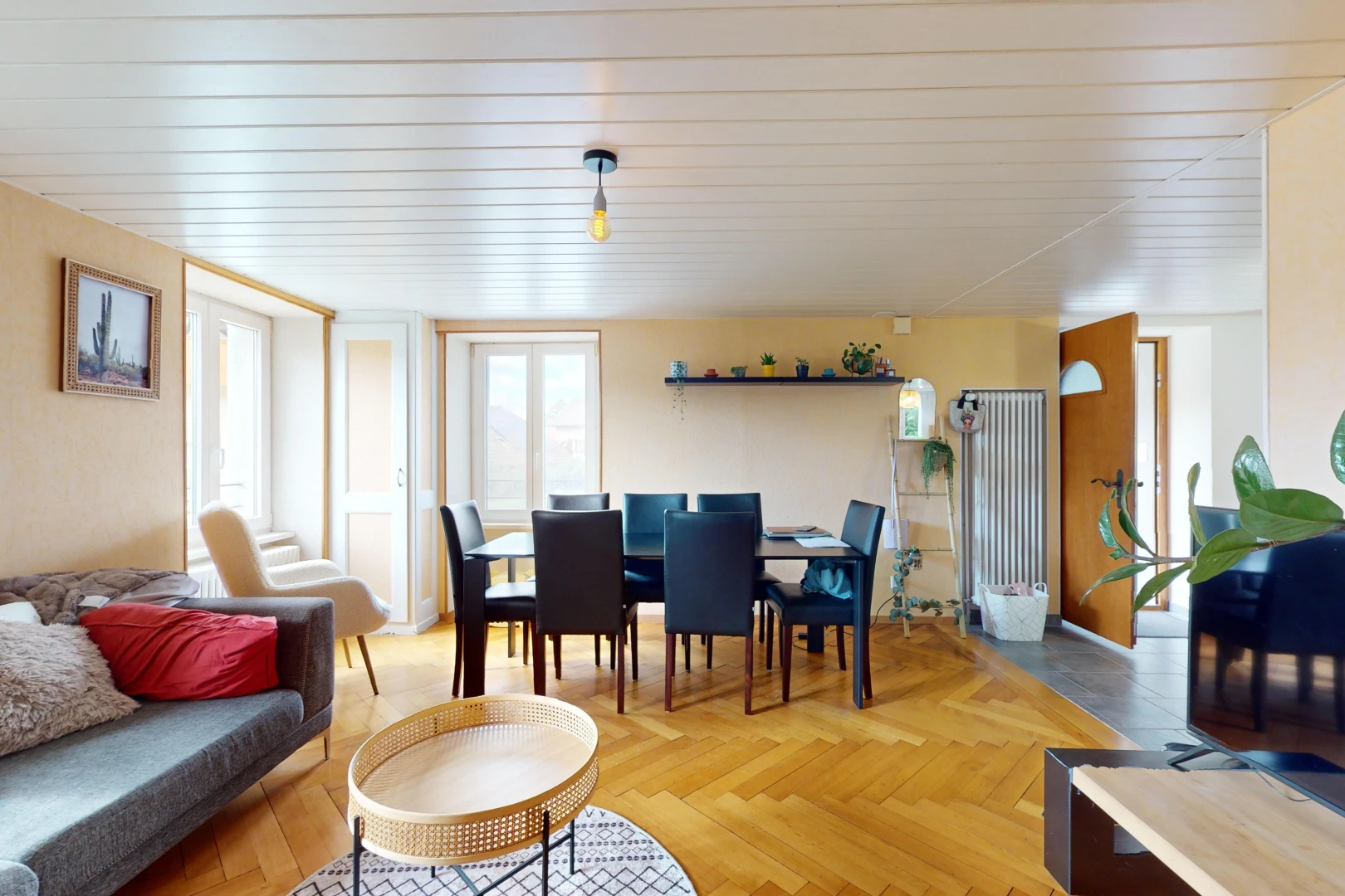 salon / salle à manger avec parquet, télévision, et lumière naturelle