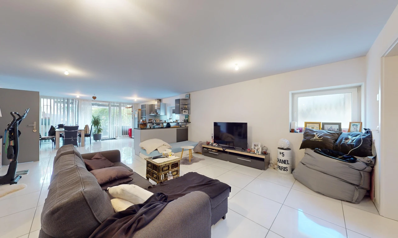 salon avec carrelage, télévision, et lumière naturelle