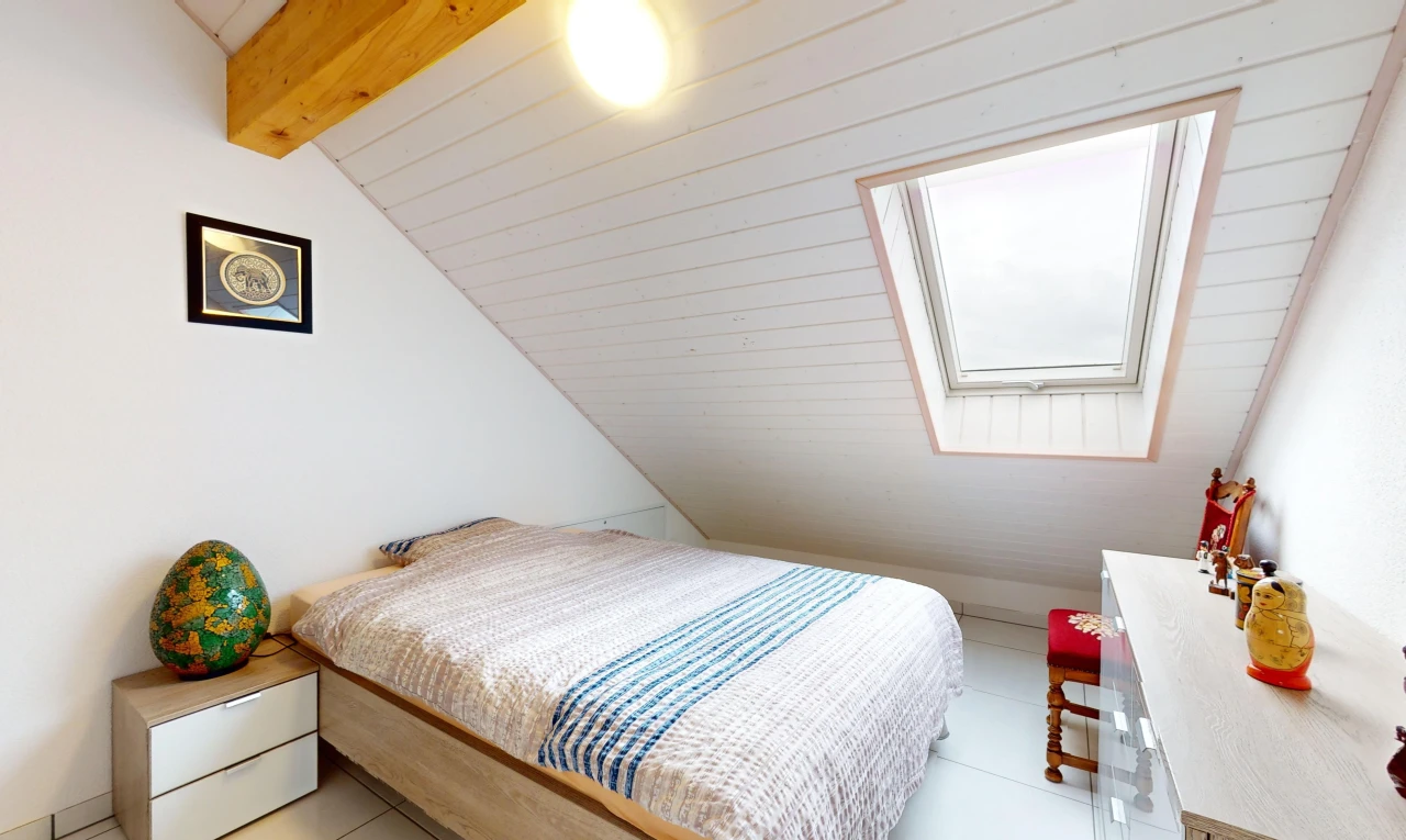 chambre avec poutres apparentes, carrelage, lumière naturelle, plafond voûté, et lucarne