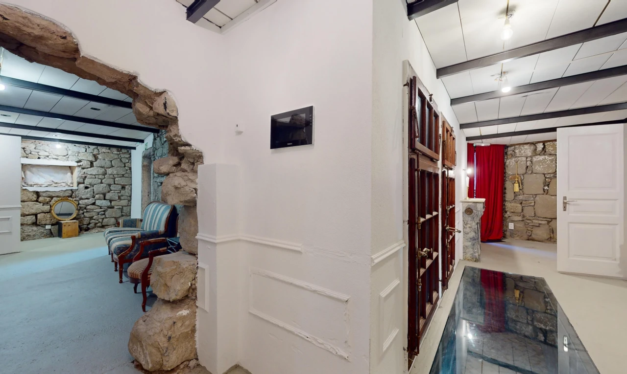 espace intérieur avec mur en pierre et poutres apparentes