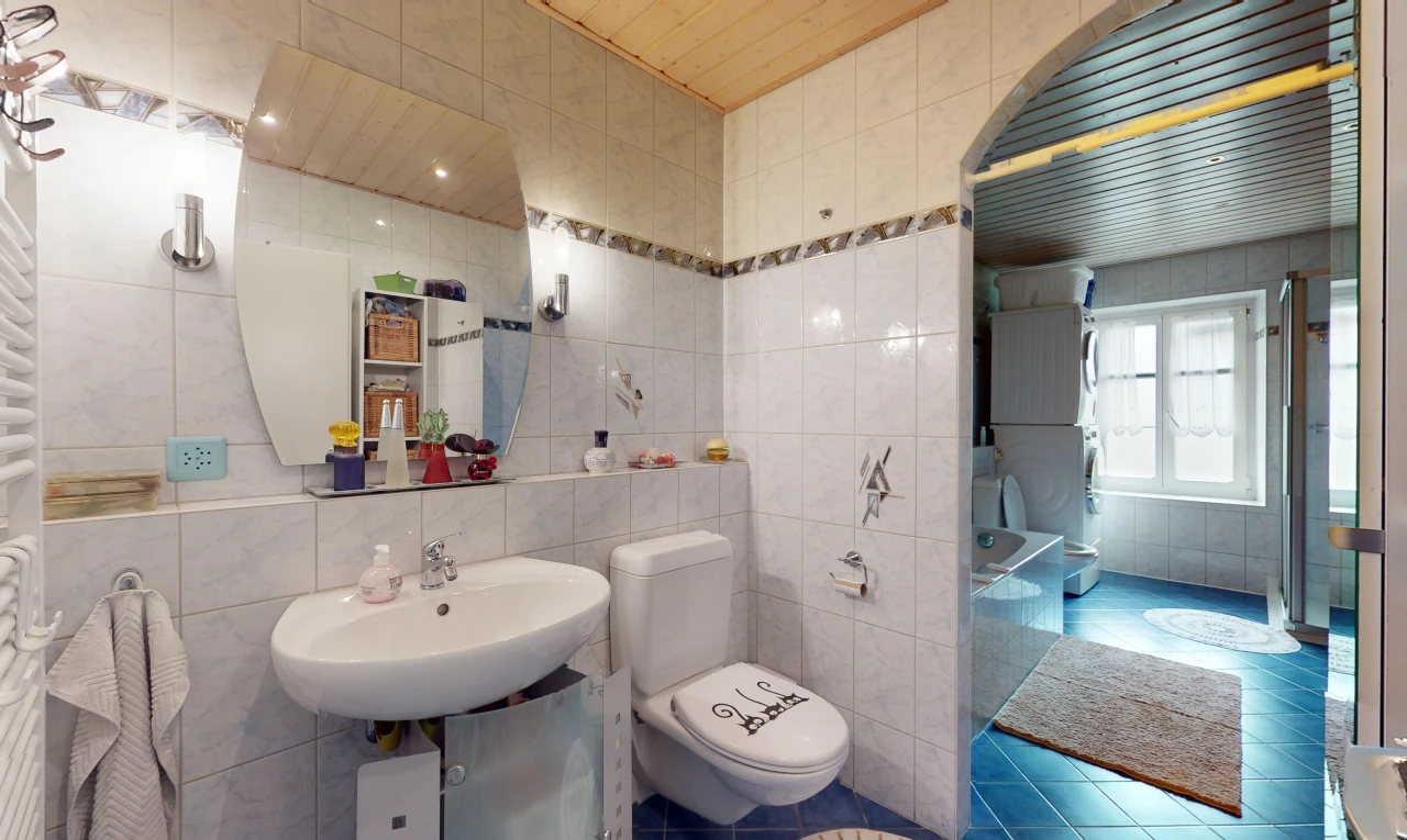 salle de bains avec mur carrelé et miroir
