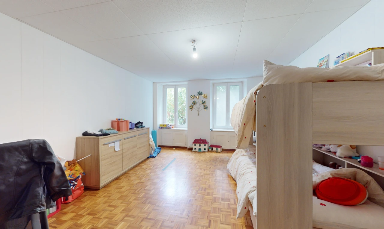 chambre avec porte-fenêtre, parquet, et lumière naturelle