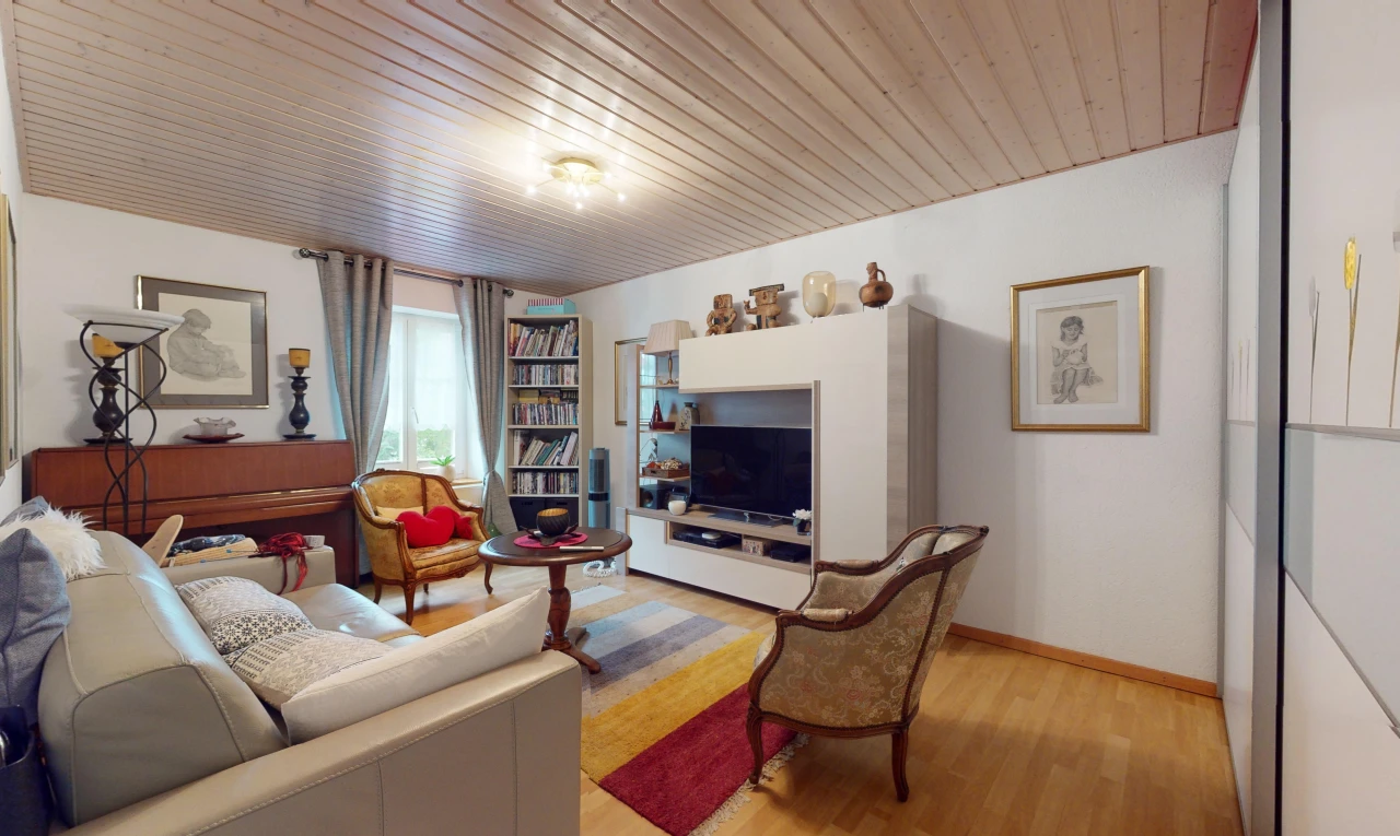 salon avec télévision, lumière naturelle, plancher de bois, et plafond de bois