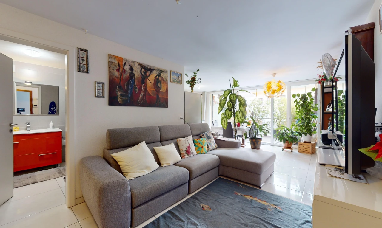 salon avec télévision, lumière naturelle, vasque, et carrelage