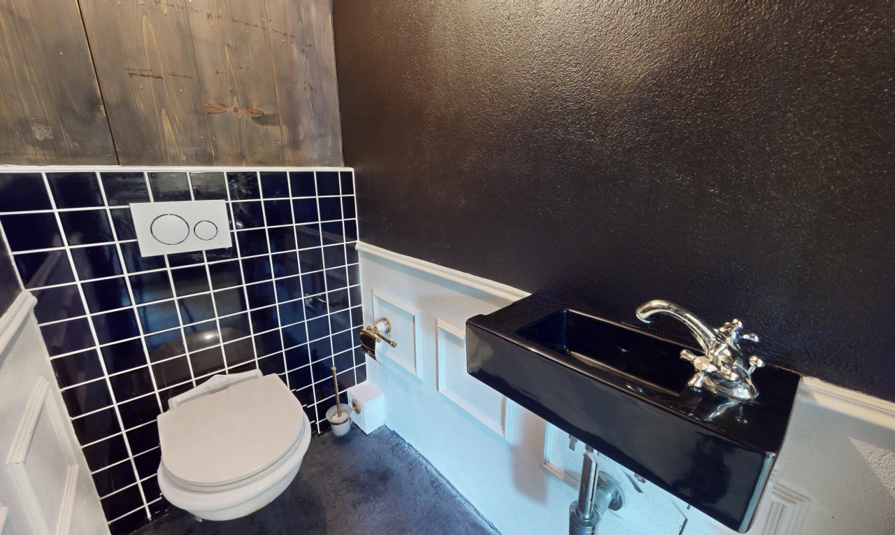 salle de bains avec toilettes et mur carrelé