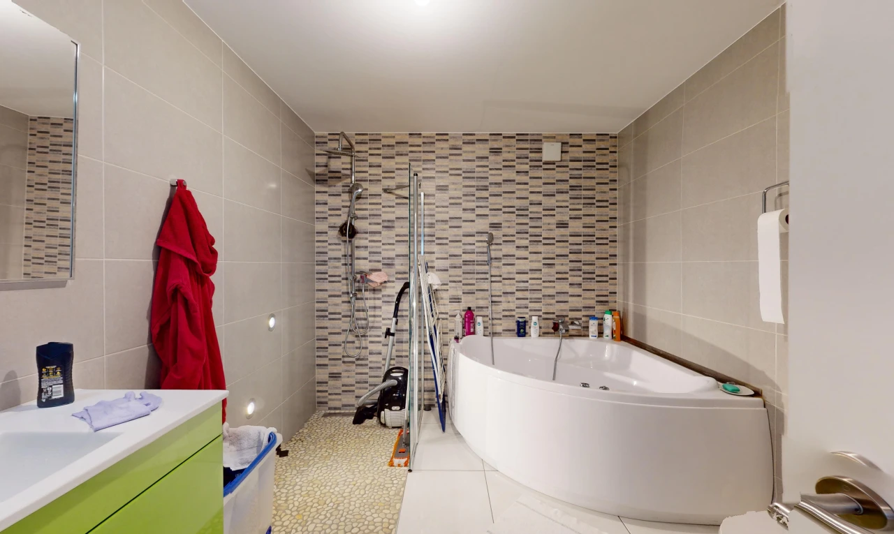 salle de bains avec mur carrelé, carrelage, baignoire, et meuble-lavabo