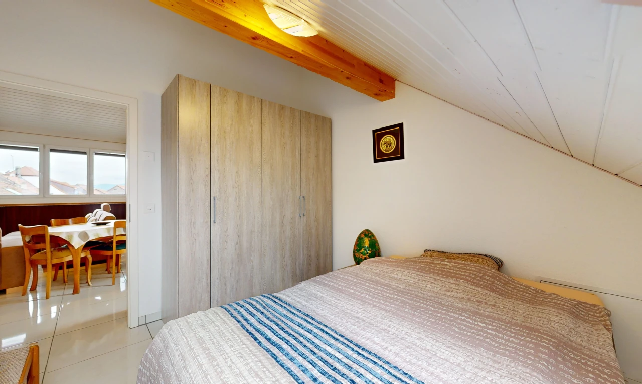 chambre avec lumière naturelle, carrelage, et poutres apparentes