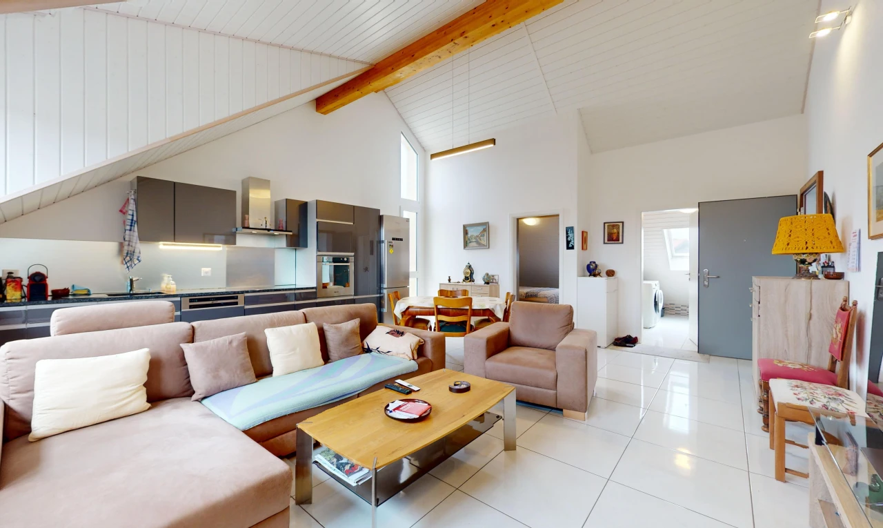 salon avec haut plafond, poutres apparentes, carrelage, lumière naturelle, et plafond voûté
