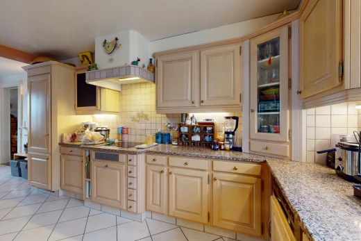 kitchen featuring decorative backsplash, light tile patterned floors, light brown cabinets, and light stone countertops