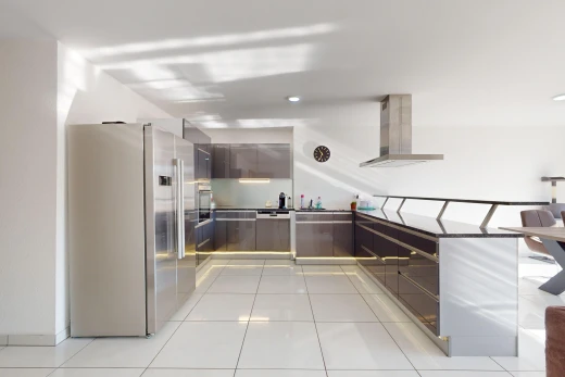 kitchen featuring high quality fridge, light tile patterned floors, and wall chimney exhaust hood