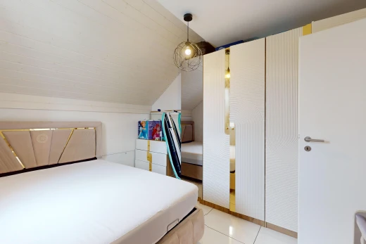 room / bedroom featuring light tile patterned flooring, lofted ceiling, and a closet