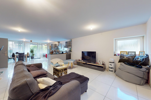 salon avec carrelage, télévision, et lumière naturelle