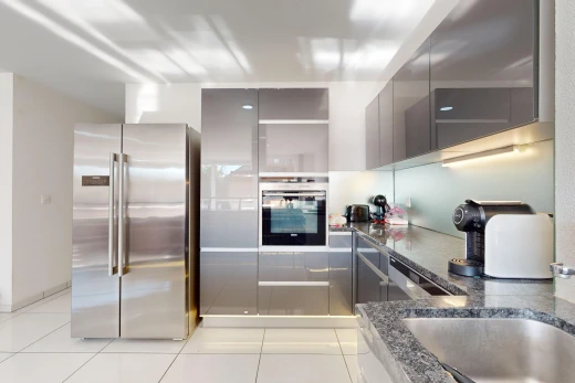 kitchen with dark stone counters, stainless steel appliances, and light tile patterned floors