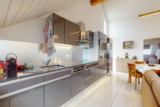 kitchen featuring light tile patterned floors, beamed ceiling, black electric stovetop, sink, and wall chimney range hood