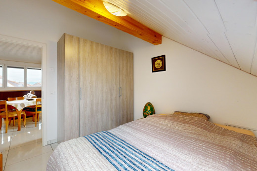 chambre avec lumière naturelle, carrelage, et poutres apparentes