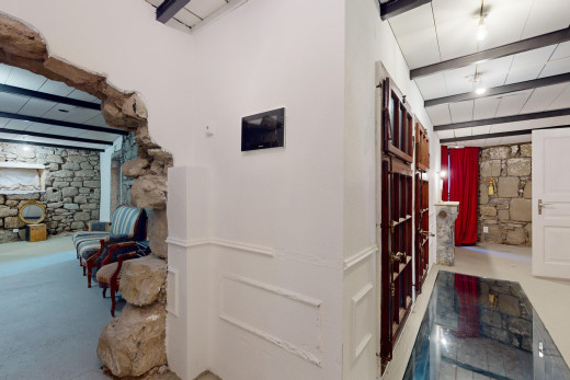 espace intérieur avec mur en pierre et poutres apparentes