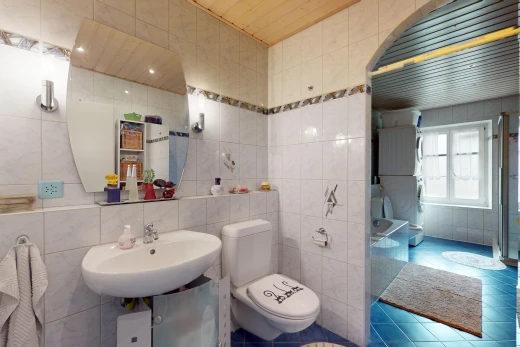bathroom with tile walls, toilet, and sink