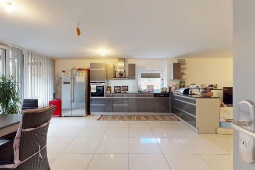 kitchen with wall chimney exhaust hood, stainless steel appliances, gray cabinets, and light tile patterned floors