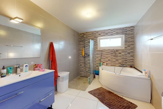 bathroom featuring plus walk in shower, tile walls, tile patterned flooring, and vanity