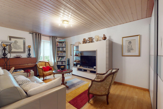 salon avec télévision, lumière naturelle, plancher de bois, et plafond de bois
