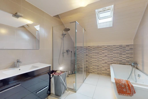 bathroom featuring tile walls, vanity, independent shower and bath, lofted ceiling with skylight, and tile patterned floors