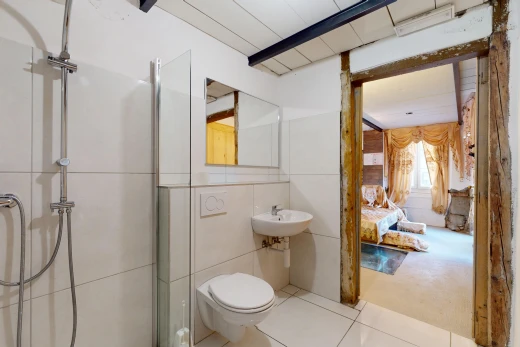 bathroom with tile walls, toilet, a shower with door, and tile patterned floors