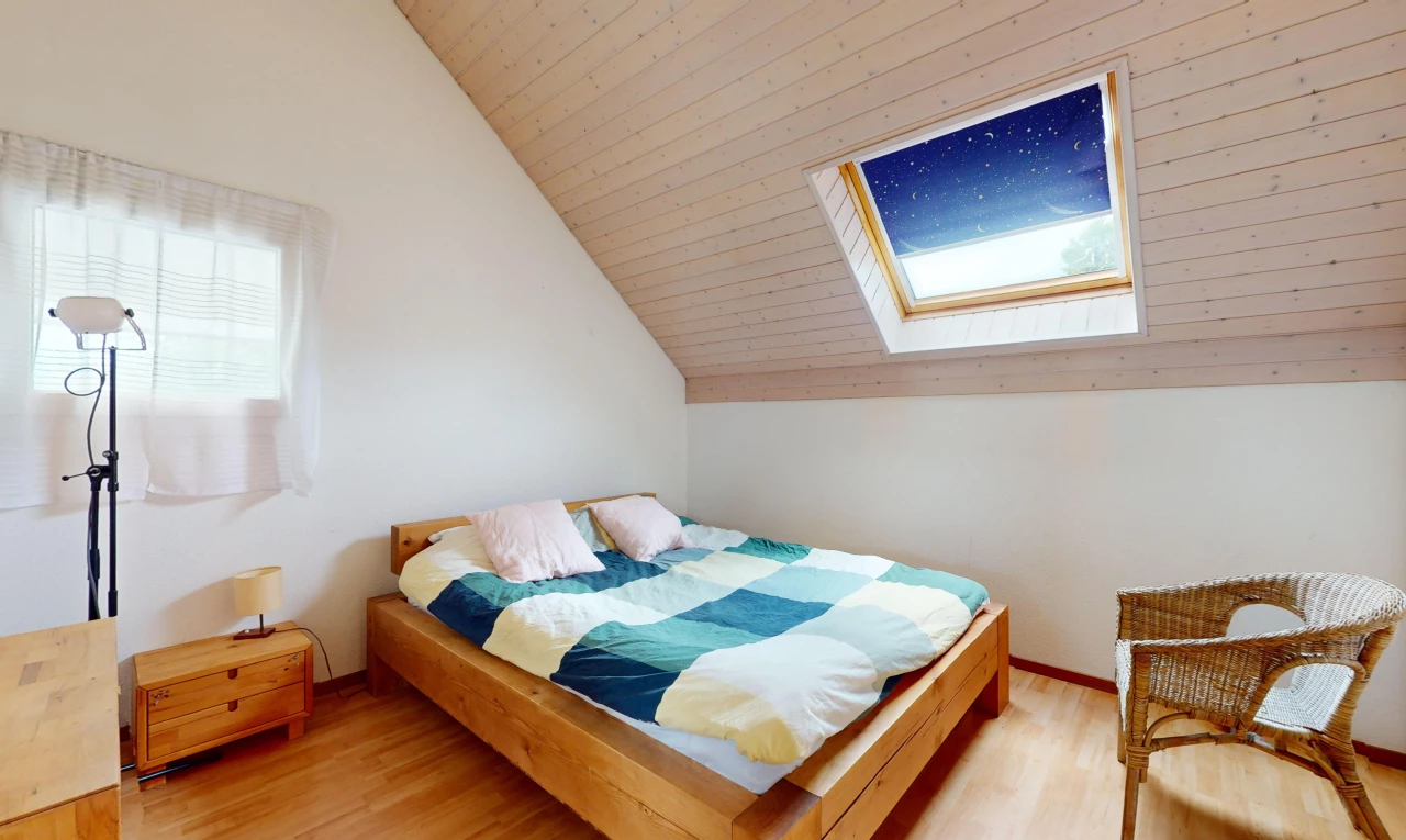chambre avec plancher de bois, plafond voûté, lucarne, et lumière naturelle