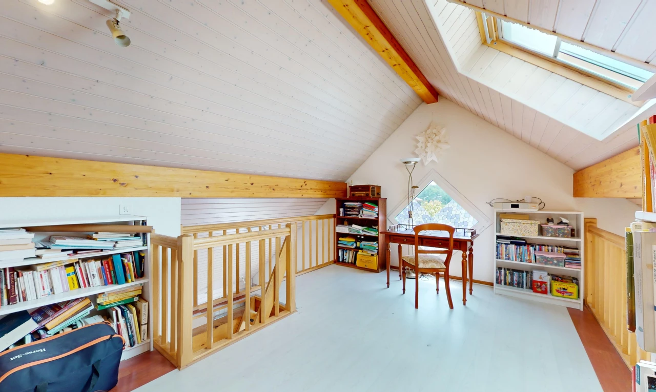 chambre avec plancher de bois, lucarne, lumière naturelle, poutres apparentes, et plafond voûté