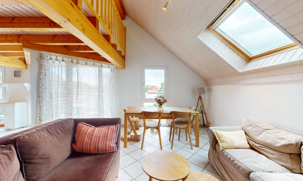 salon / salle à manger avec poutres apparentes, carrelage, lumière naturelle, lucarne, et plafond voûté