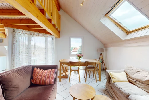 salon / salle à manger avec poutres apparentes, carrelage, lumière naturelle, lucarne, et plafond voûté