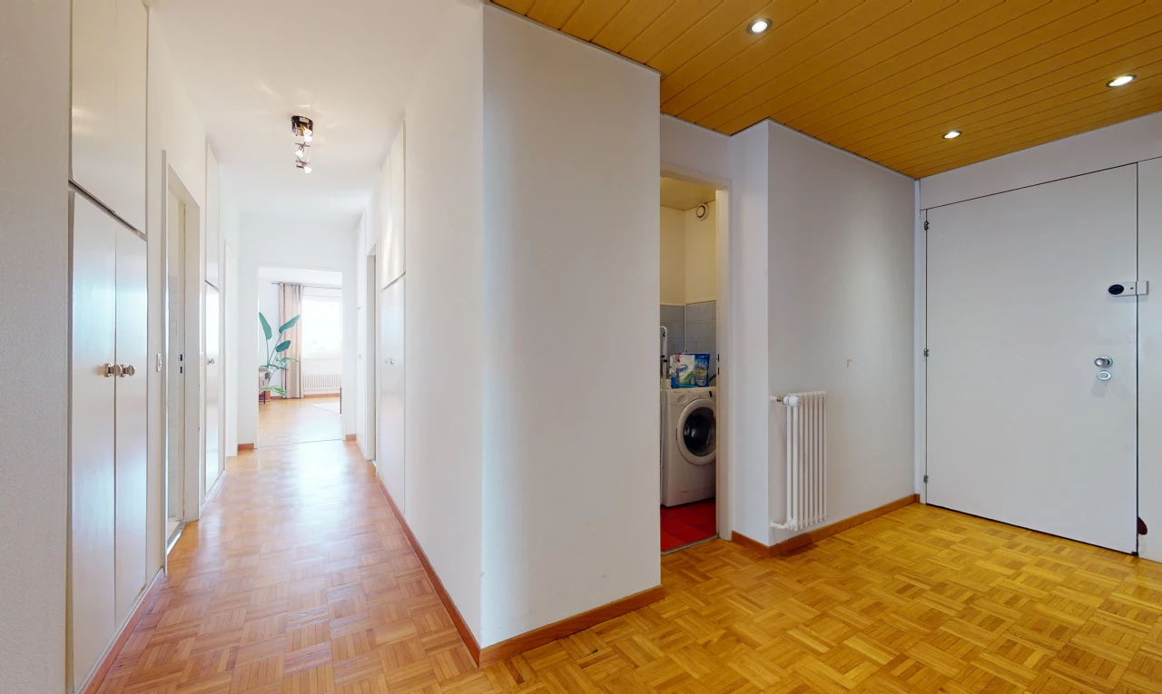 couloir avec parquet, radiateur, et machine à laver / sèche-linge