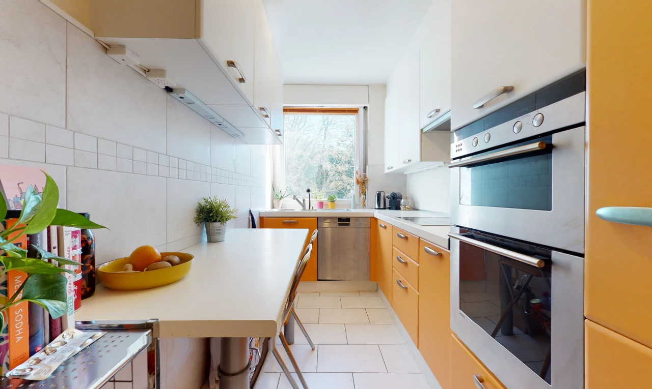 cuisine avec carrelage, lumière naturelle, acier inoxydable, four, lave-vaisselle, comptoirs claires, et sol clair