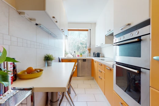 cuisine avec carrelage, lumière naturelle, acier inoxydable, four, lave-vaisselle, comptoirs claires, et sol clair