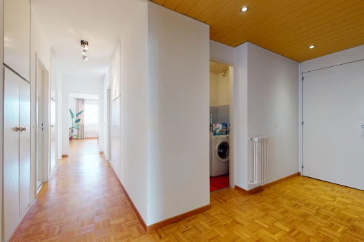 couloir avec parquet, radiateur, et machine à laver / sèche-linge