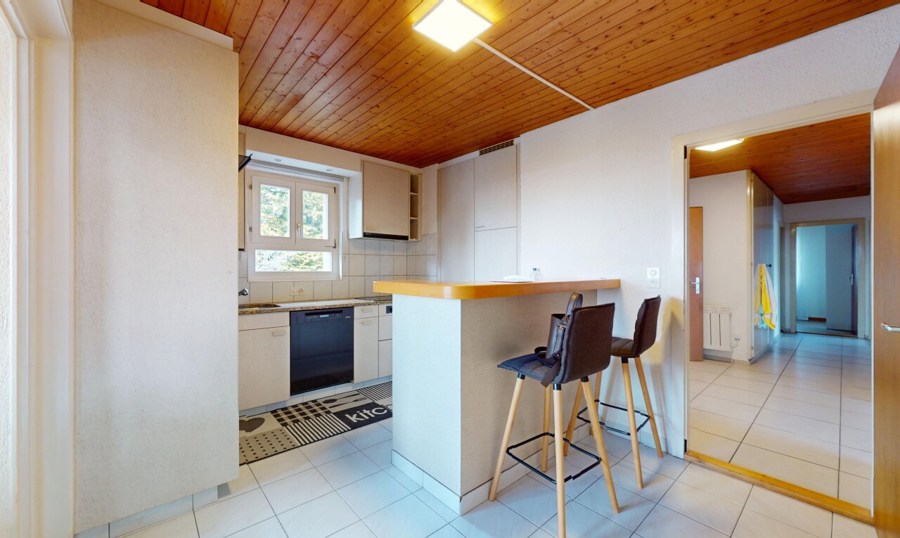 cuisine avec plafond en bois, dosseret, lumière naturelle, bar de cuisine, et lave-vaisselle